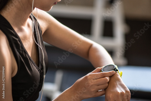 Beautiful young woman using smart watch at the gym