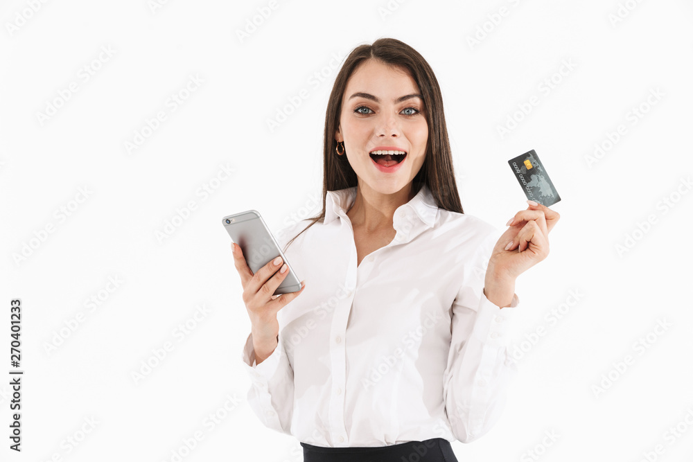 Photo of charming female worker businesswoman dressed in formal wear holding smartphone and credit card while working in office Photo of charming female worker businesswoman dressed in formal wear holding smartphone and credit card while working in office