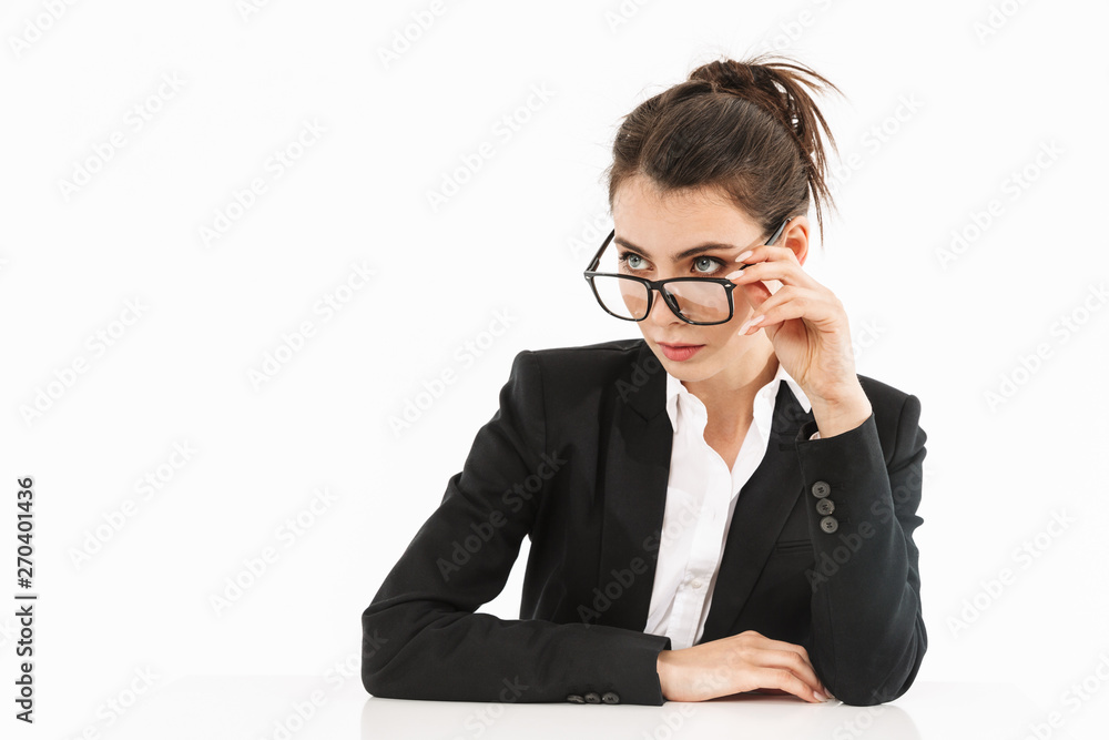 Photo of caucasian female worker businesswoman dressed in formal wear looking aside while working and sitting at desk in office