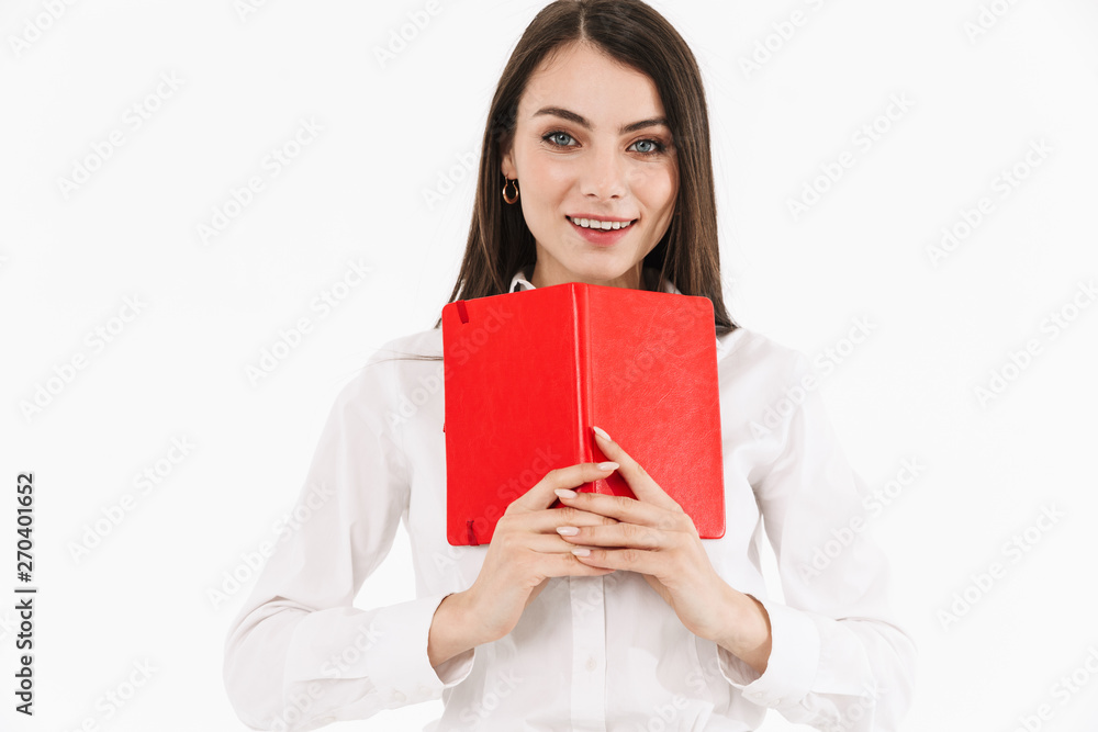 Photo of smiling female worker businesswoman dressed in formal wear holding day planner while working in office Photo of smiling female worker businesswoman dressed in formal wear holding day planner while working in office