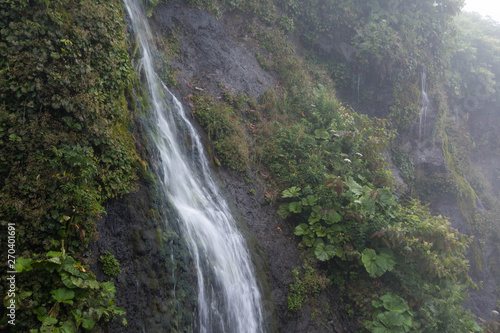 緑の岩肌を流れる滝