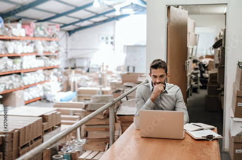 Manager working online while sitting in a warehouse office photo