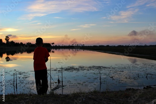  The silhouette of children on the banks of the blue sky and gold in the evening