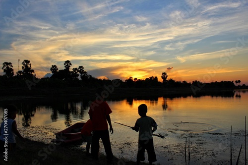  The silhouette of children on the banks of the blue sky and gold in the evening