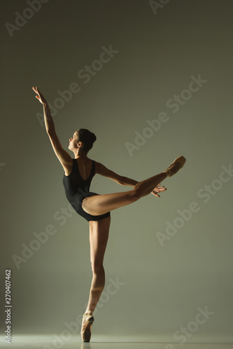 Graceful ballet dancer or classic ballerina dancing isolated on grey studio background. Showing flexibility and grace. The dance, artist, contemporary, movement, action and motion concept.