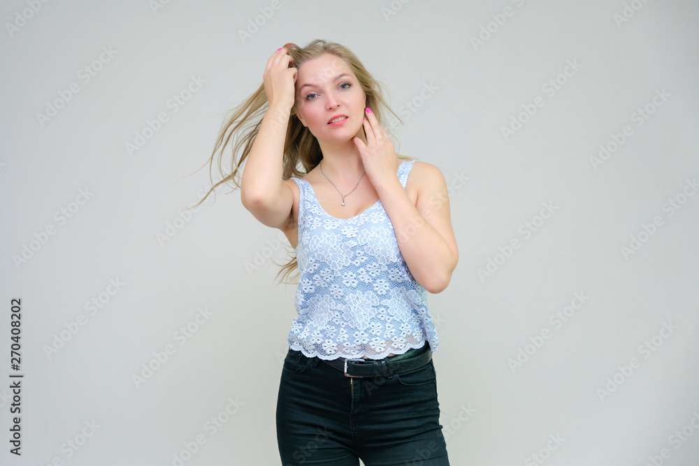 Fototapeta premium Life is beautiful and I like everything here. I am satisfied with life and I wish you. Portrait of a smiling beautiful blonde girl on a gray background in various poses.