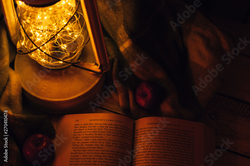 lamp with warm light, book and apples