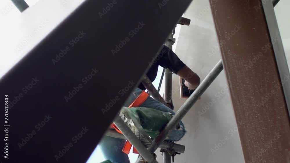 Vid??o Stock Construction worker up scaffolding in safety gear reaching