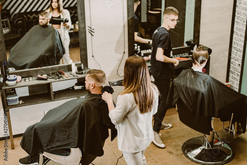 hairdressers cut their clients in the salon