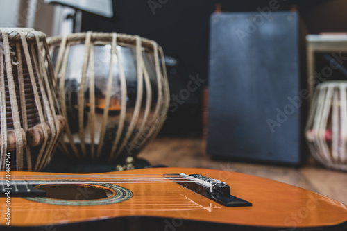 Obraz na plátně Acoustic guitar, cajon and tabla - view of the musical instruments used for fusion eastern and western music, and also jazz and blues