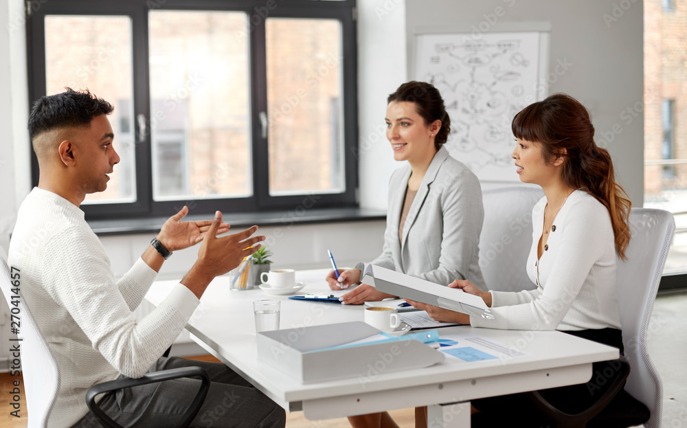 new job, hiring and employment concept - international team of recruiters having interview with indian male employee at office new job, hiring and employment concept - international team of recruiters having interview with indian male employee at office