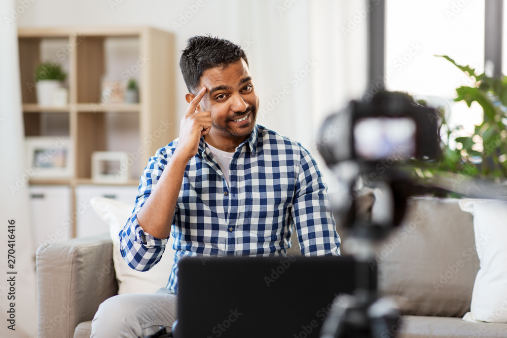 blogging, videoblog and people concept - indian male blogger with camera recording video at home blogging, videoblog and people concept - indian male blogger with camera recording video at home