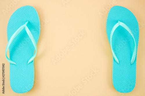 Frame mockup blue beach slippers isolated on a pastel beige background. Top view with copy space