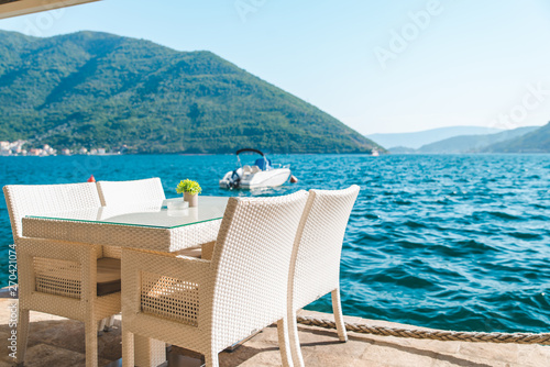 cafe table on beach with beautiful view of sea and mountains