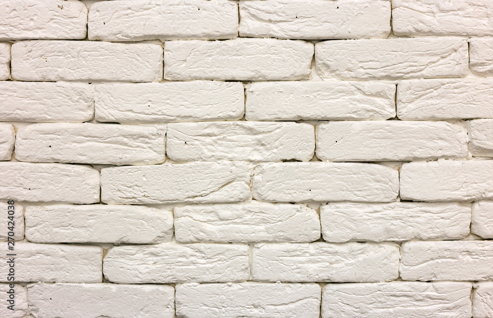 Fototapeta premium Close-up of white painted whitewashed solid brick wall. Abstract copy space background, Bricklaying, construction and masonry concept.