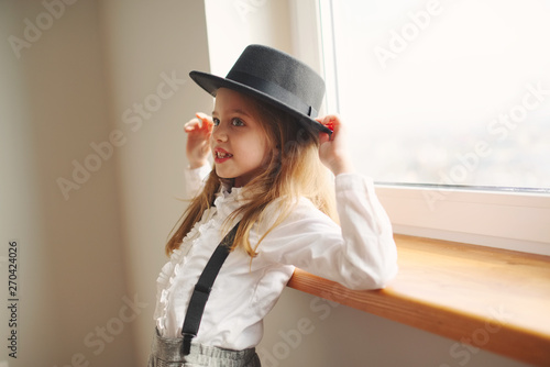 cute little girl with black hat at home