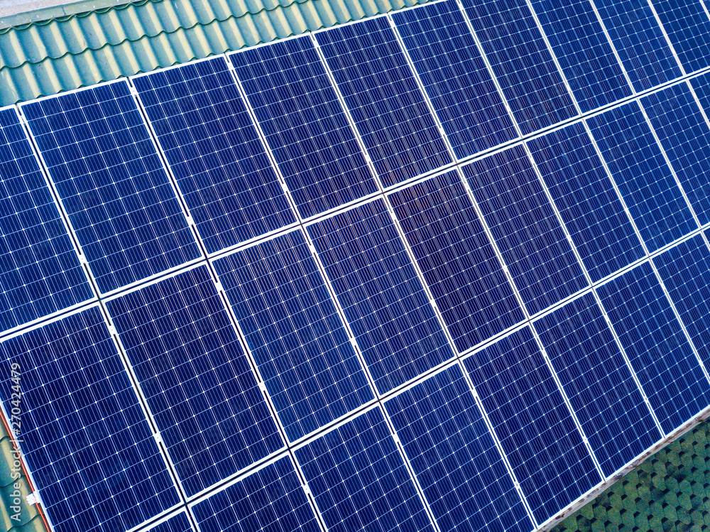 Close-up surface of blue shiny solar photo voltaic panels system on building roof. Renewable ecological green energy production concept. Close-up surface of blue shiny solar photo voltaic panels system on building roof. Renewable ecological green energy production concept.