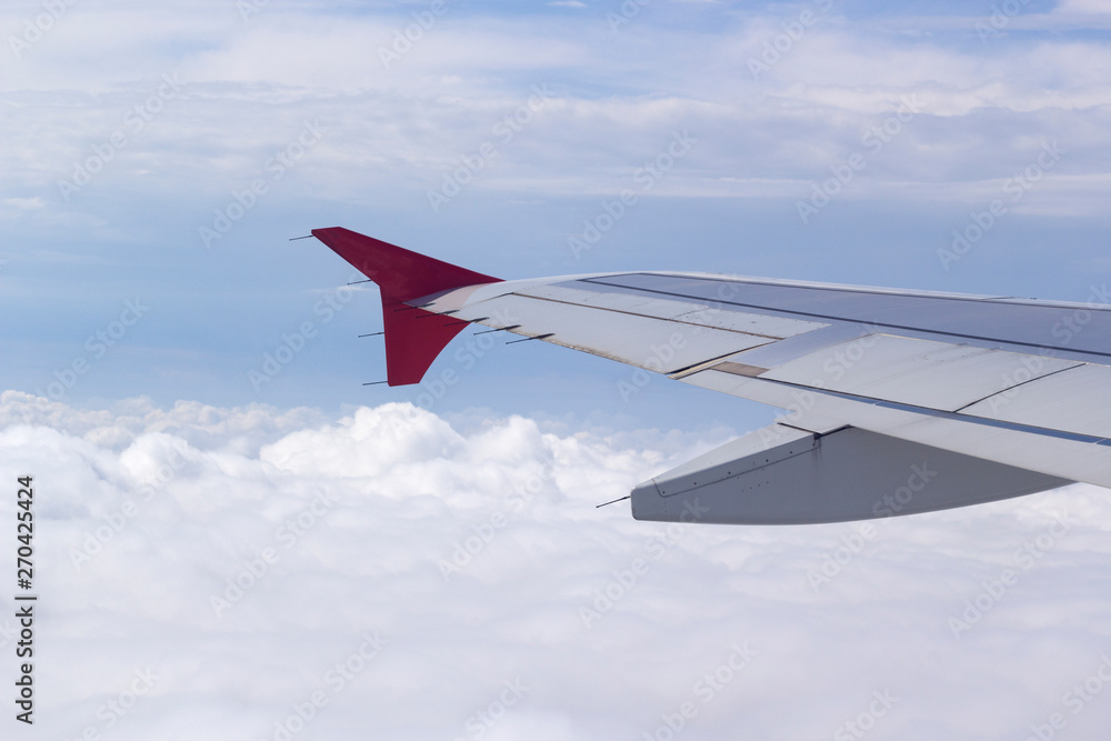 wing of a plane against a blue sky with clouds wing of a plane against a blue sky with clouds