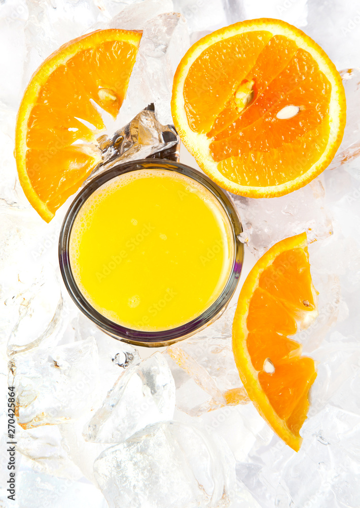 top view of glass of orange juice in ice with orange slices top view of glass of orange juice in ice with orange slices