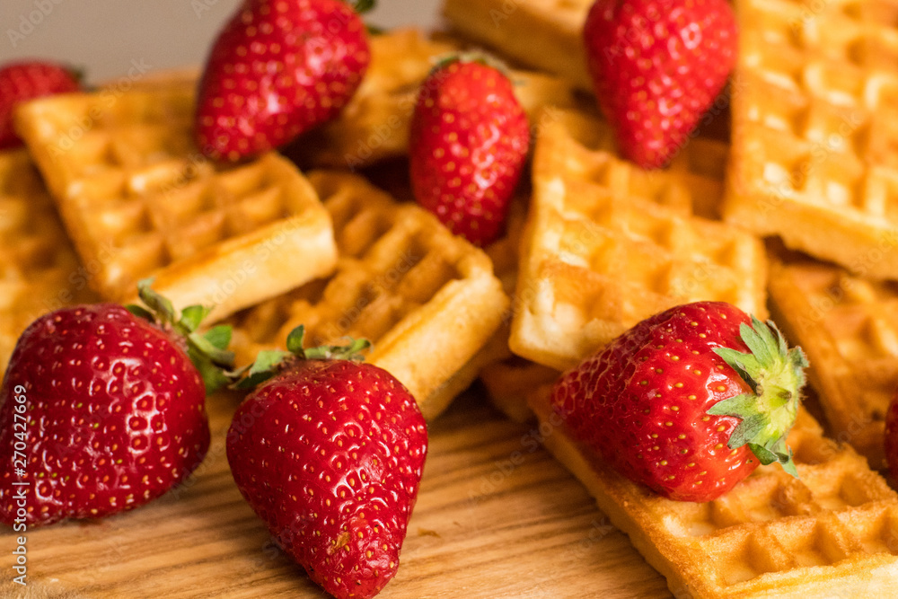 Close up of belgian waffles with strawberries on the table Close up of belgian waffles with strawberries on the table