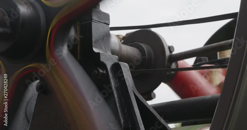 Fast spinning flywheel on a steam roller, close up.