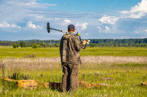 Treasure hunter in the field with a metal detector