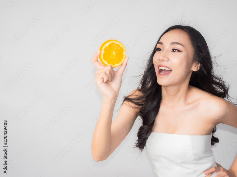 portrait asian beautiful woman.Closeup beauty skin face young girl.isolated white background. female holding orange portrait asian beautiful woman.Closeup beauty skin face young girl.isolated white background. female holding orange