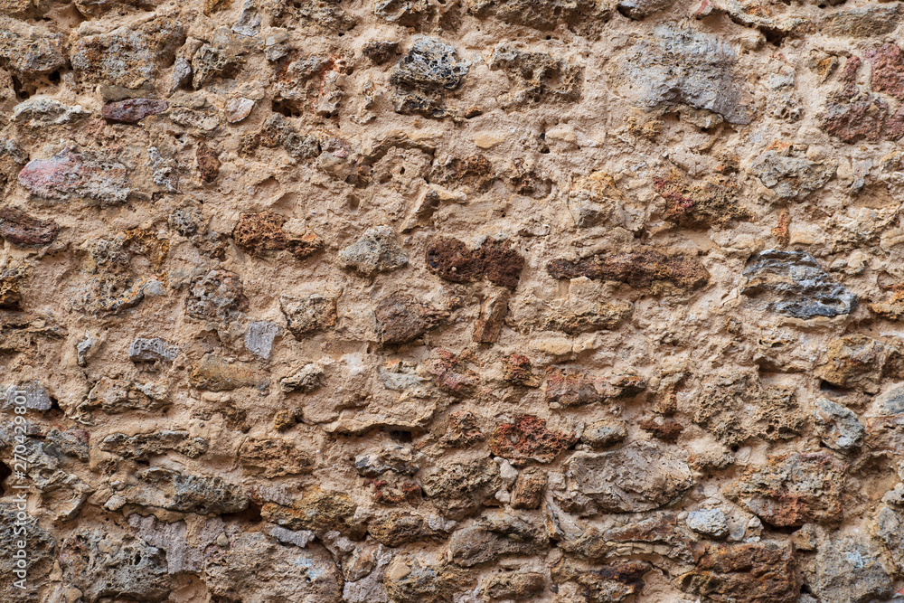 Background of a medieval wall made of old rustic stone Background of a medieval wall made of old rustic stone