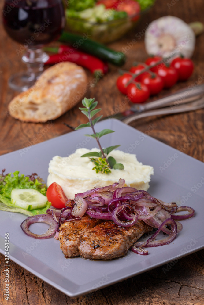 Gegrilltes Schweinesteak mit Zwiebeln