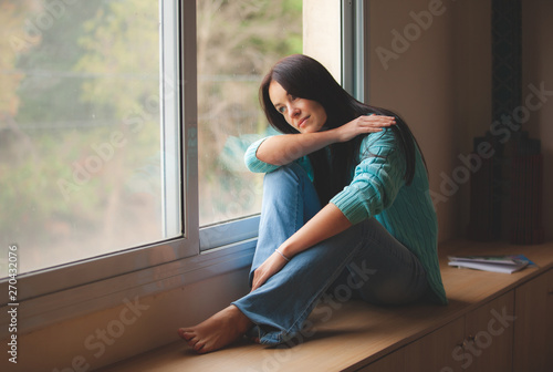 woman sitting on the window sill Free Download woman sitting on the window sill - GFXLoad