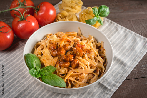 Italian spaghetti and meatballs topped with fresh basil