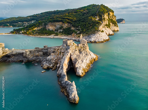 Aerial view of the Gothic-style Church of St. Peter sitting atop a rocky headland in Porto Venere village, Liguria, Italy