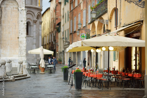 Beautifully decorated small outdoor restaurant tables in the city of Lucca, Italy