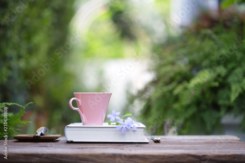 Fototapeta Naklejka Na Ścianę i Meble -  Pink coffee cup with small flowers and notebook 