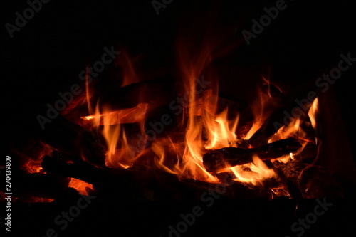 Night fire. The logs of the trees quietly smoldering some burn with a small flame creating a relaxing mood.