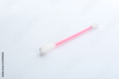 Pink plastic cotton swab on white background