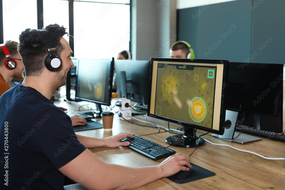 Man playing video game in internet cafe