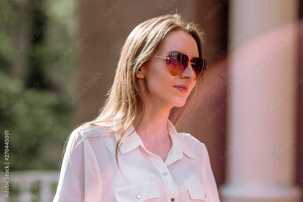 Beautiful girl in sunglasses on the background of trees Beautiful girl in sunglasses on the background of trees