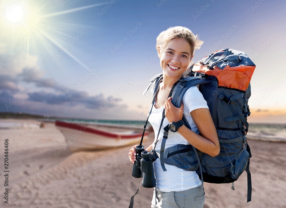Woman with backpack trekking through the wilderness Woman with backpack trekking through the wilderness