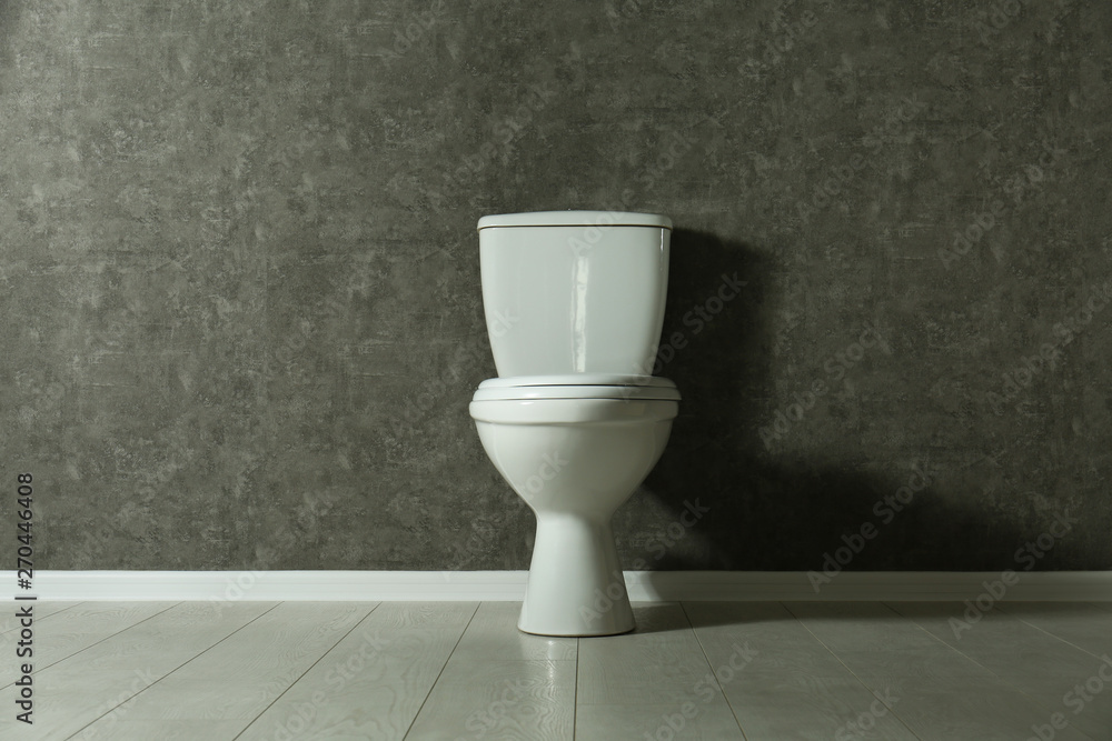 New toilet bowl near grey wall indoors New toilet bowl near grey wall indoors