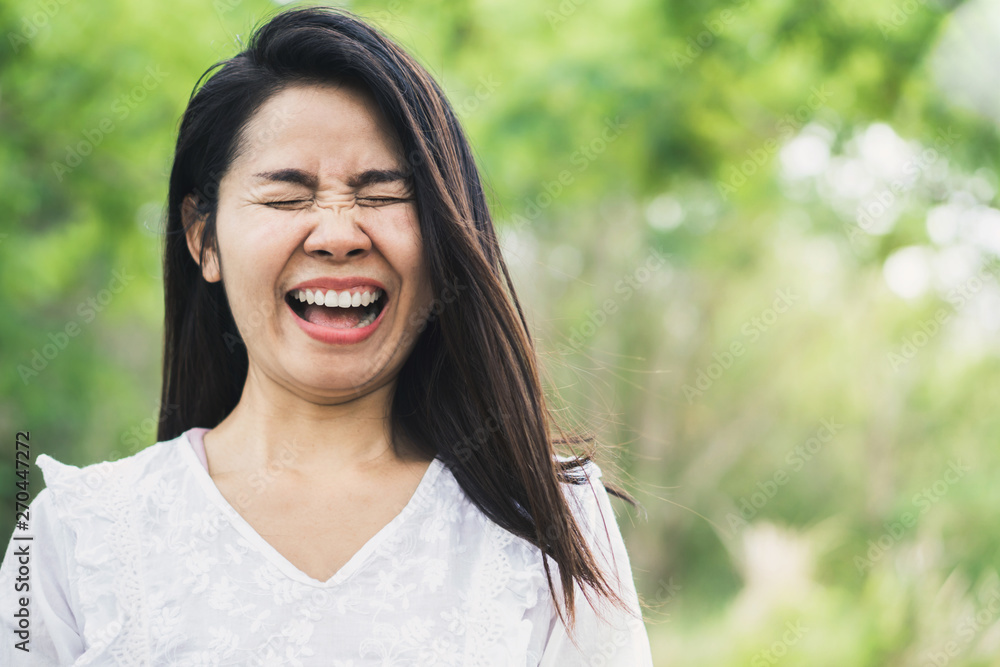 happy Asian woman laughing outdoor with green park nature background happy Asian woman laughing outdoor with green park nature background