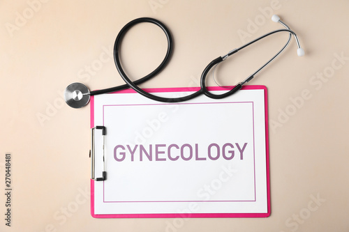 Clipboard with word Gynecology and stethoscope on color background, flat lay