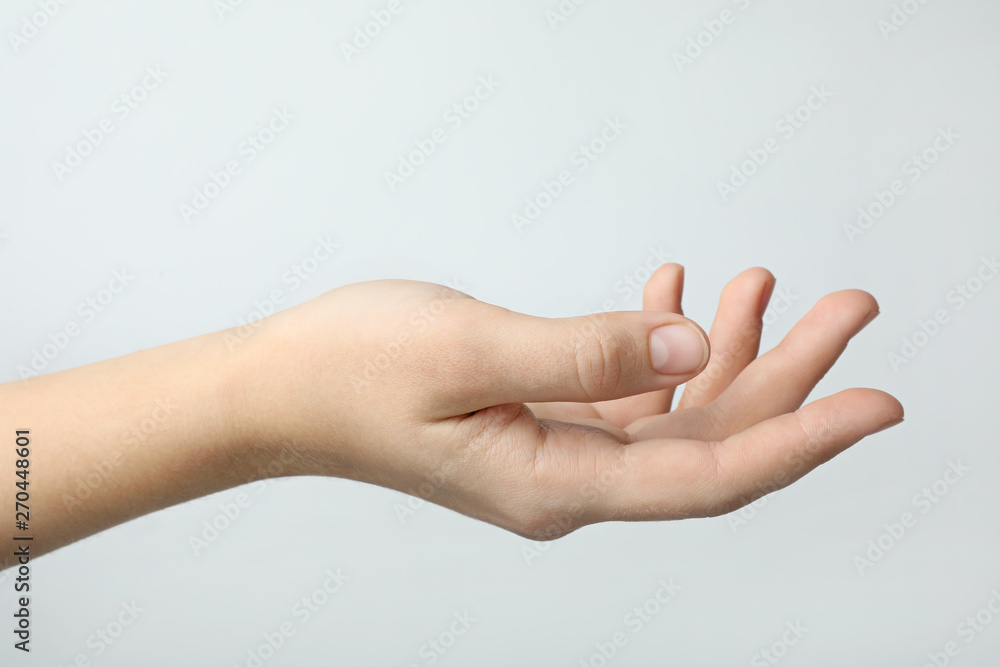 Woman holding something against light background, focus on hand Woman holding something against light background, focus on hand