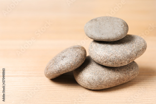Stack of spa stones on wooden table. Space for text