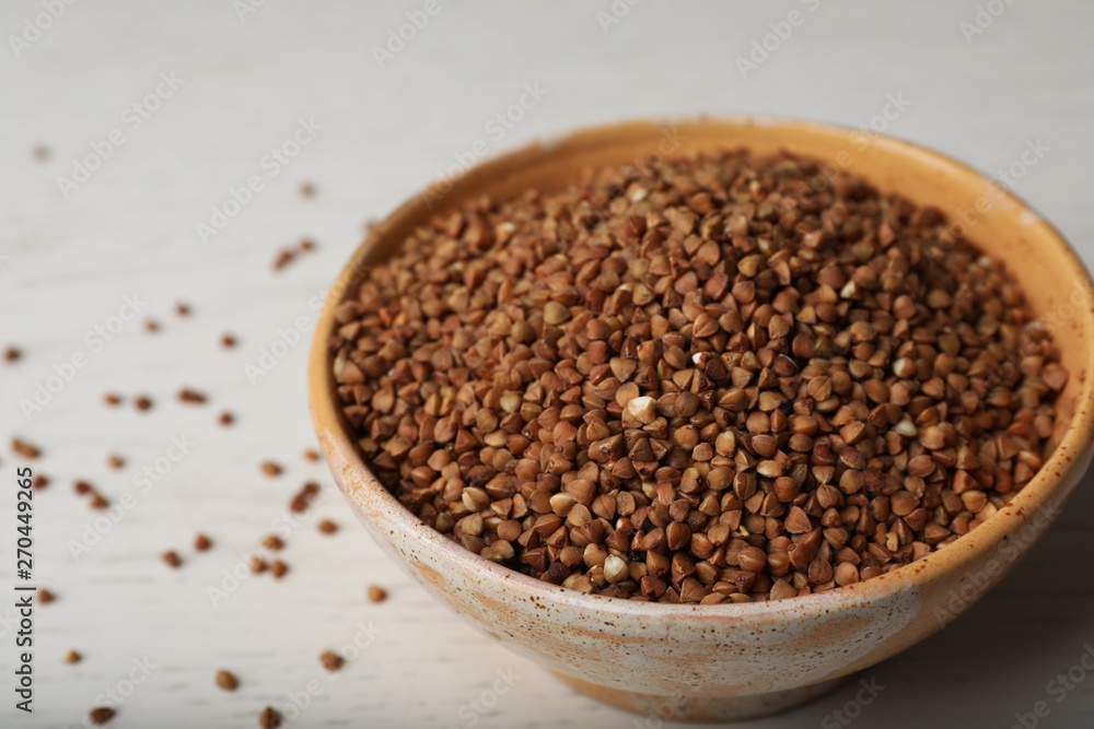 Uncooked buckwheat in ceramic bowl on table Uncooked buckwheat in ceramic bowl on table