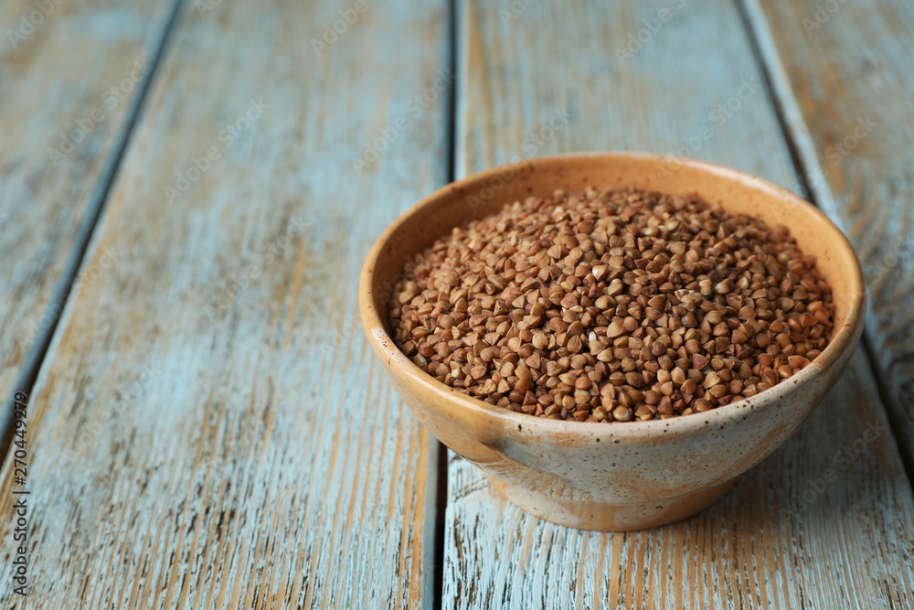Uncooked buckwheat in bowl on table. Space for text Uncooked buckwheat in bowl on table. Space for text