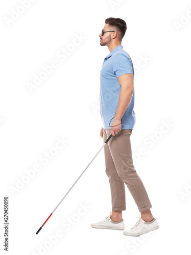 Young blind person with long cane walking on white background