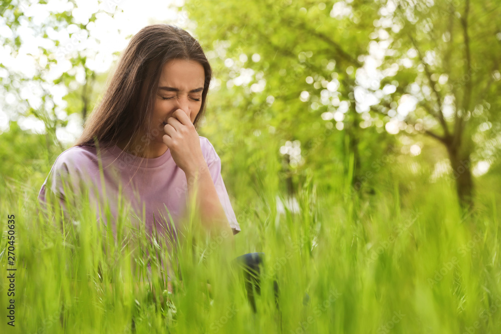 Young woman suffering from seasonal allergy outdoors, space for text Young woman suffering from seasonal allergy outdoors, space for text