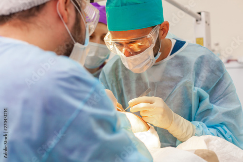 Baldness treatment. Hair transplant. Surgeons in the operating room carry out hair transplant surgery. Surgical technique that moves hair follicles from a part of the head. photo