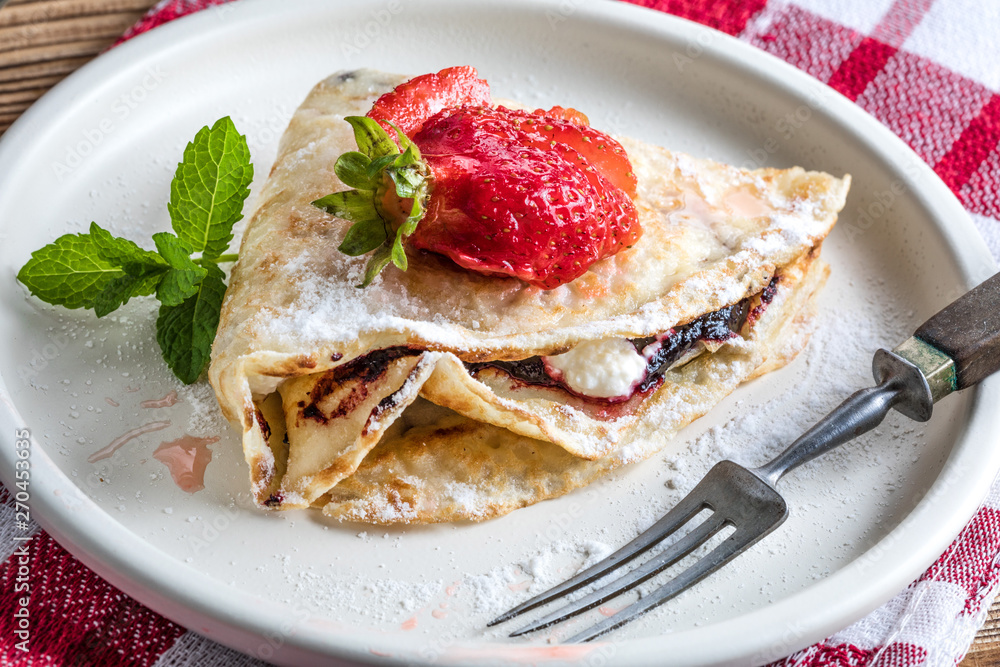 Polish pancakes with jam, cheese and strawberries. Polish pancakes with jam, cheese and strawberries.